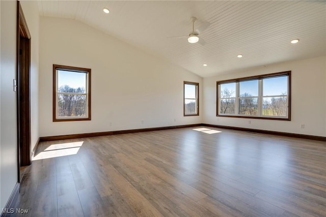 unfurnished room featuring lofted ceiling, recessed lighting, wood finished floors, and baseboards