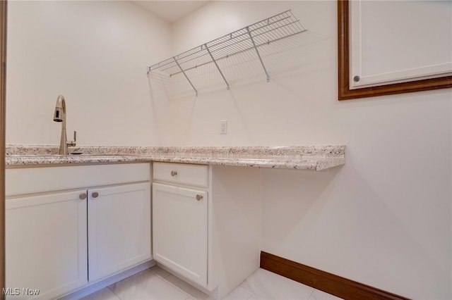 laundry room with a sink and baseboards