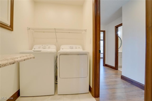 laundry area featuring laundry area, independent washer and dryer, light wood-type flooring, and baseboards