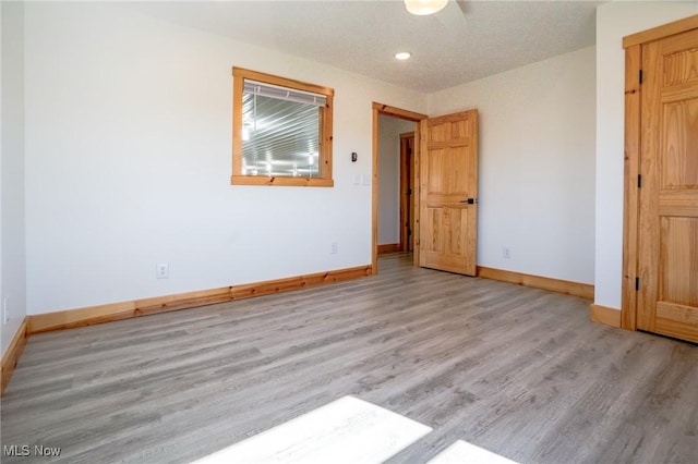 unfurnished bedroom with recessed lighting, wood finished floors, and baseboards