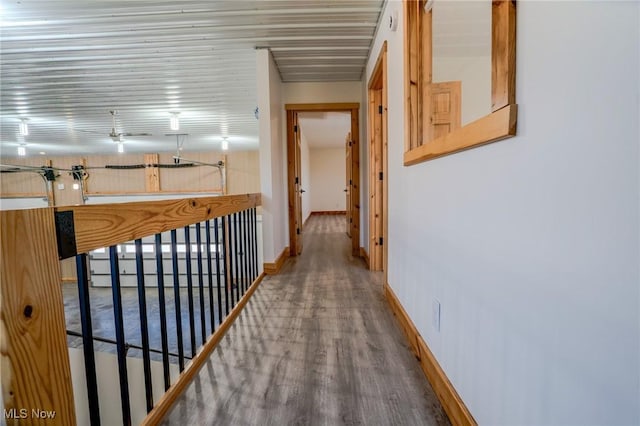 hall featuring baseboards and wood finished floors