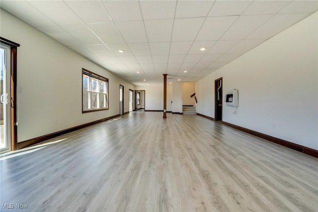 spare room with recessed lighting, a drop ceiling, baseboards, and wood finished floors