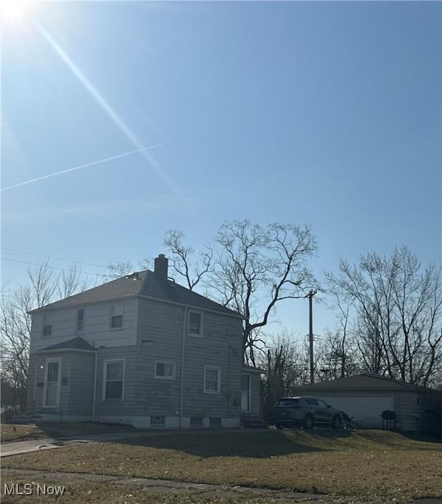 view of side of property featuring a garage and a chimney