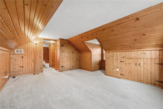 bonus room with visible vents, wooden walls, wooden ceiling, and vaulted ceiling