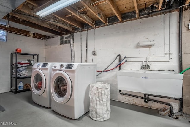 washroom with washer and clothes dryer, laundry area, and a sink