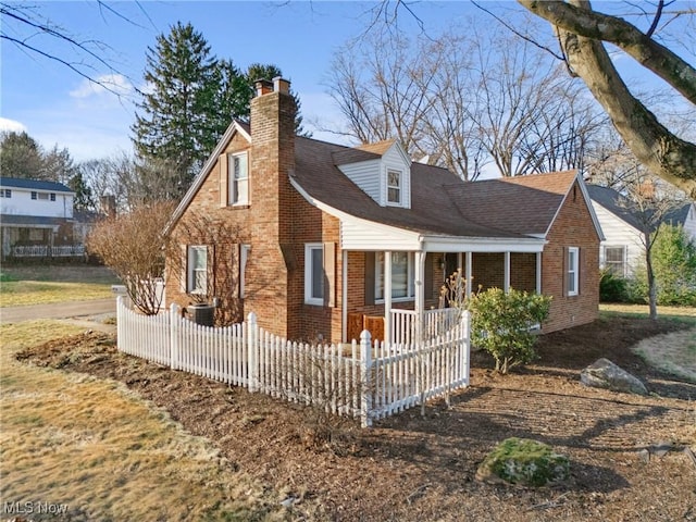 view of front of property with fence, brick siding, covered porch, and a chimney