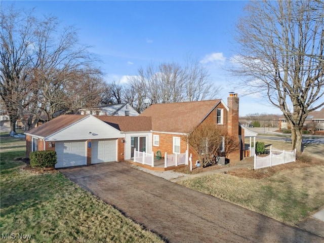 view of front of house featuring driveway, fence, an attached garage, brick siding, and a chimney