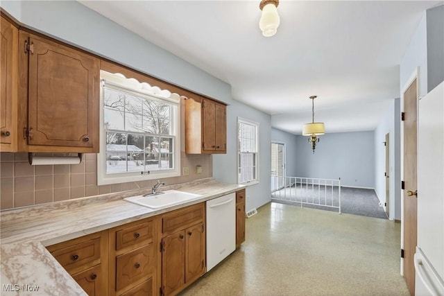 kitchen with a sink, decorative backsplash, dishwasher, and light countertops