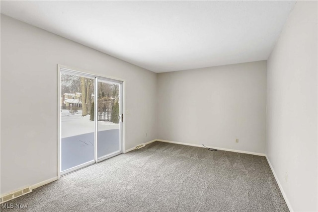 carpeted empty room with visible vents and baseboards