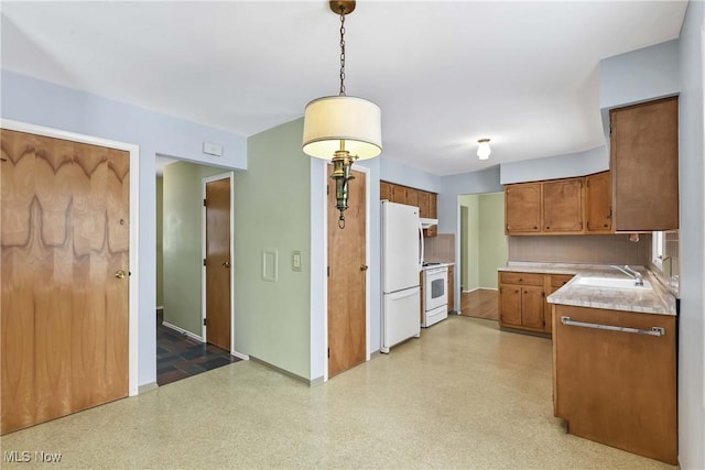 kitchen with white appliances, brown cabinetry, a sink, light countertops, and tasteful backsplash