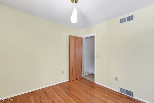 spare room featuring baseboards, visible vents, and light wood finished floors