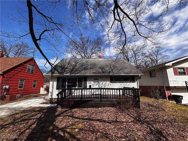 view of front of house with a chimney and driveway