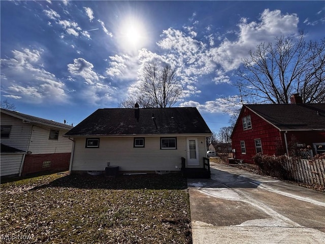 rear view of house featuring central AC and fence