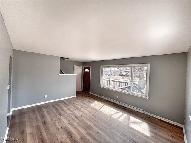 unfurnished living room featuring baseboards and wood finished floors