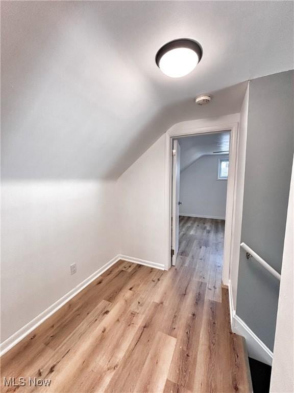 additional living space featuring vaulted ceiling, baseboards, and wood finished floors