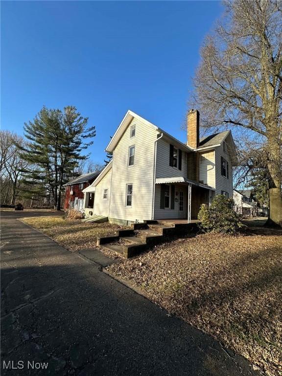 back of house with a chimney