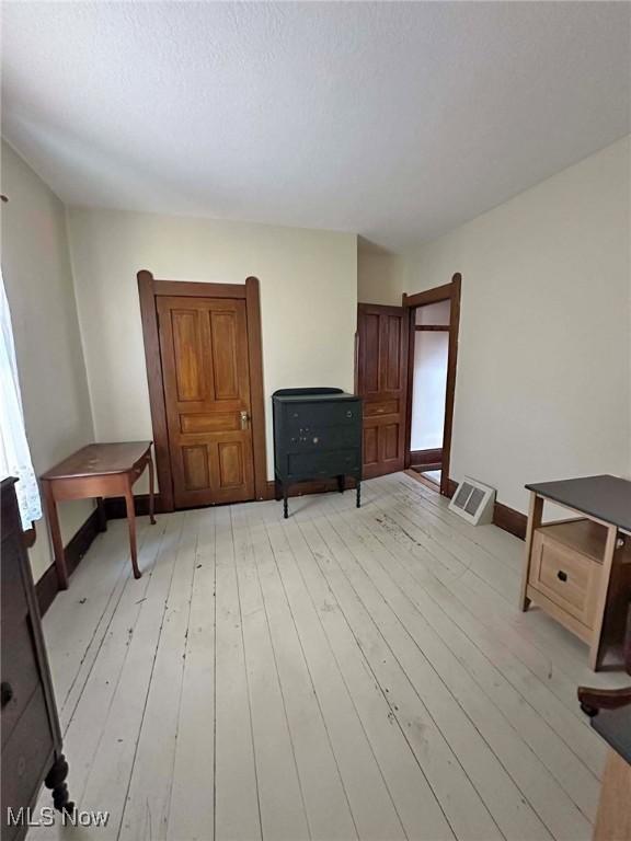 interior space with visible vents, baseboards, and light wood-style floors