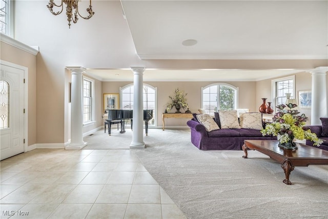 entryway with light tile patterned floors, plenty of natural light, and decorative columns