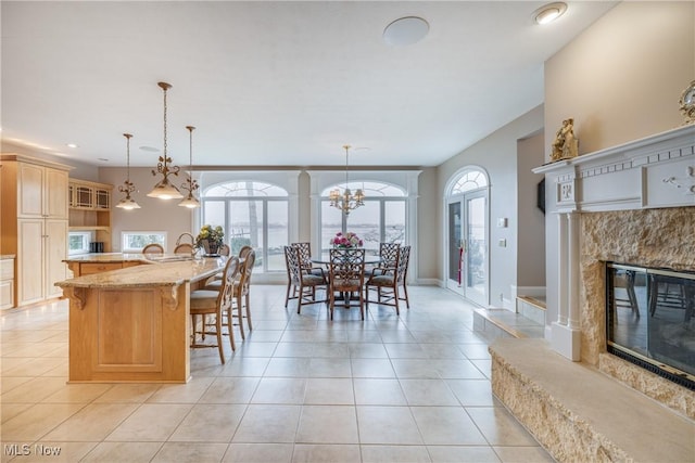 kitchen with a wealth of natural light, a fireplace, a breakfast bar area, and light tile patterned flooring