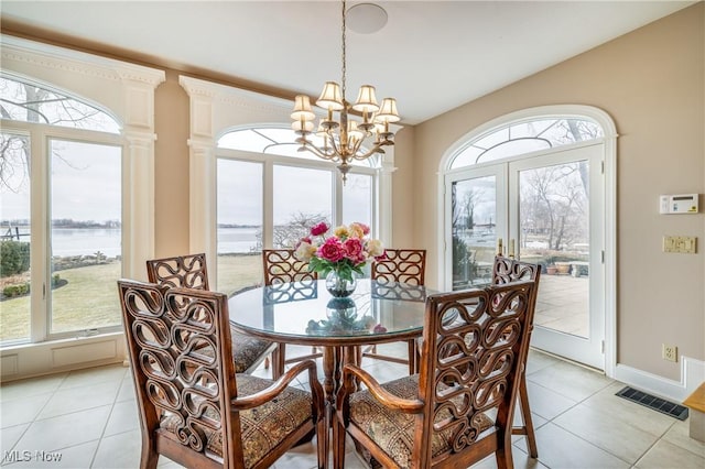 dining space featuring visible vents, a healthy amount of sunlight, light tile patterned flooring, and a chandelier