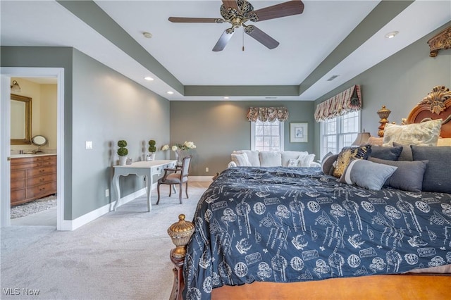 carpeted bedroom featuring recessed lighting, connected bathroom, a raised ceiling, and baseboards