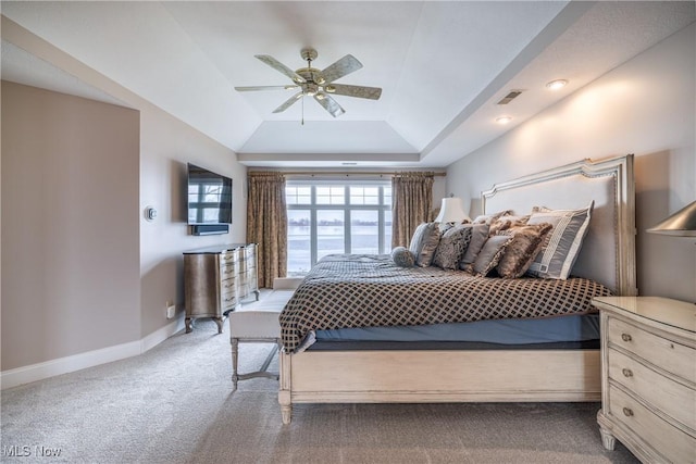 bedroom with visible vents, a tray ceiling, carpet, baseboards, and ceiling fan