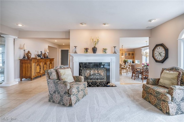 living room with tile patterned floors, carpet floors, a glass covered fireplace, and ornate columns