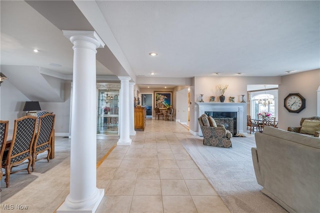 living room featuring recessed lighting, a fireplace, light tile patterned floors, baseboards, and ornate columns