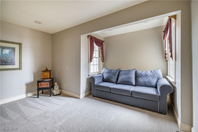 carpeted living area with baseboards