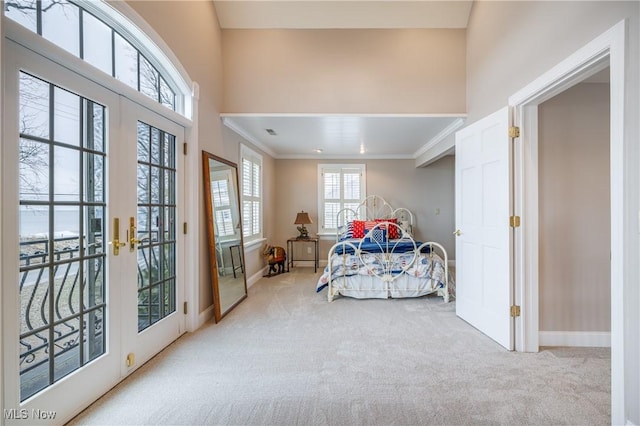 carpeted bedroom featuring access to exterior, french doors, baseboards, and ornamental molding