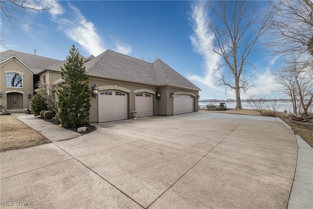 view of side of home featuring a shingled roof, a garage, driveway, and stucco siding