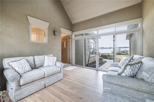 living room with high vaulted ceiling and wood finished floors