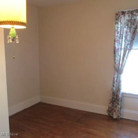 empty room with wood finished floors and baseboards