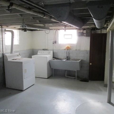 basement featuring independent washer and dryer and a sink