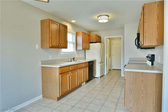 kitchen featuring a sink, baseboards, black appliances, and light countertops