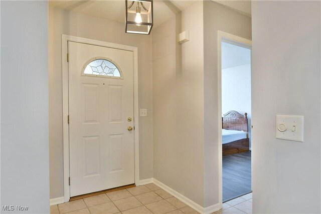 entrance foyer with light tile patterned floors and baseboards