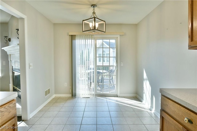 doorway featuring light tile patterned floors, visible vents, a chandelier, and baseboards