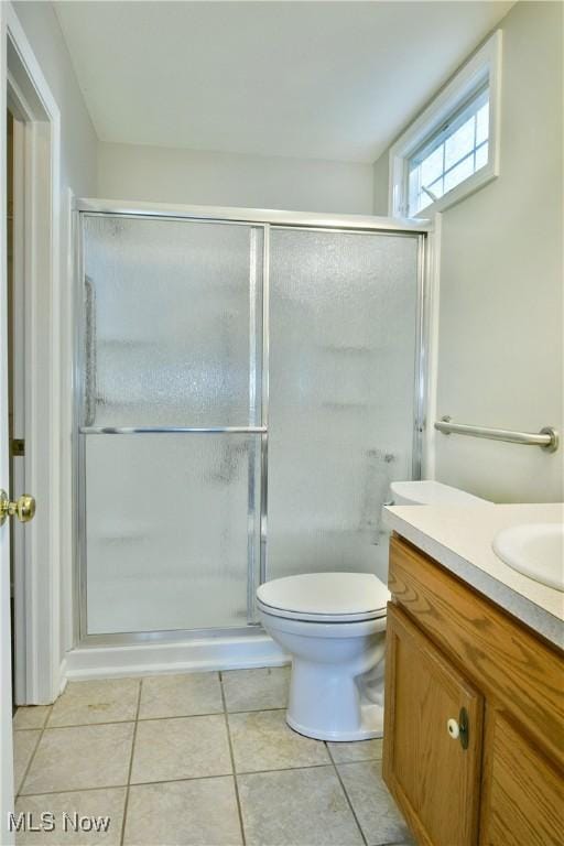 full bath with tile patterned floors, toilet, a stall shower, and vanity