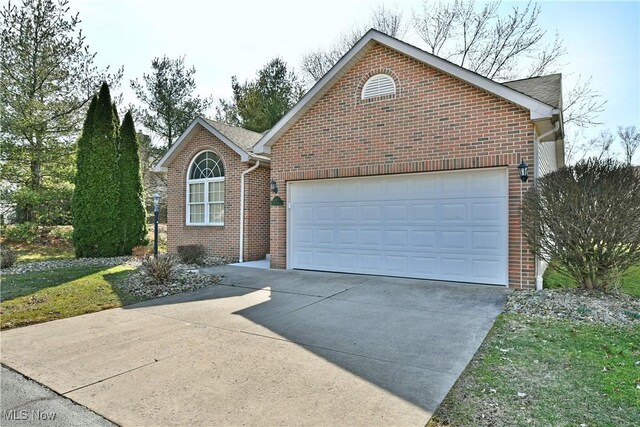 single story home featuring an attached garage, brick siding, and driveway