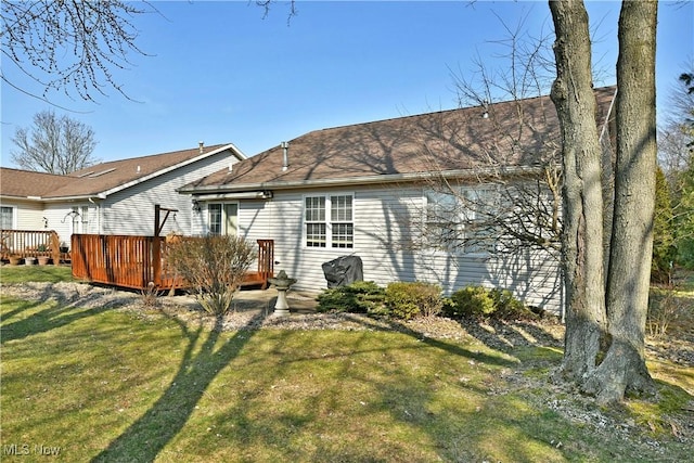 rear view of property featuring a wooden deck and a yard