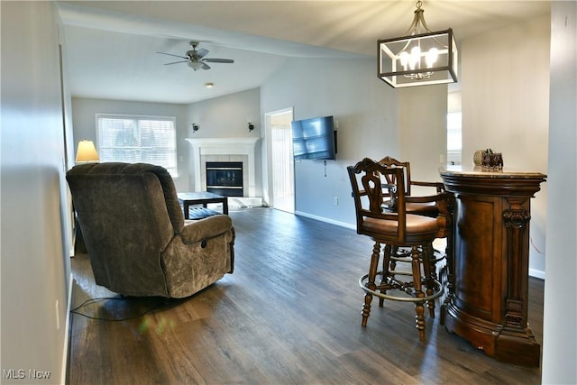 interior space with ceiling fan, a fireplace, dark wood-style flooring, and baseboards