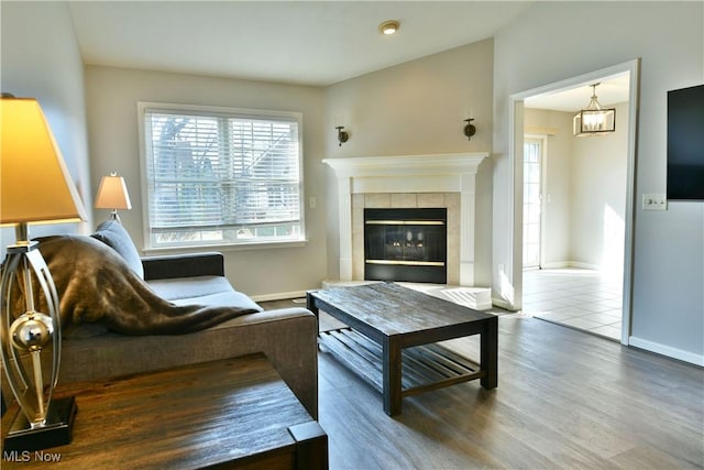 living room with wood finished floors, a fireplace, and baseboards