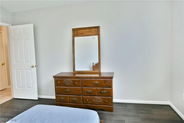 bedroom with wood finished floors and baseboards