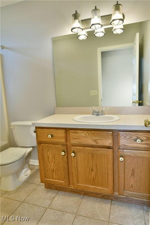 bathroom with tile patterned flooring, toilet, and vanity