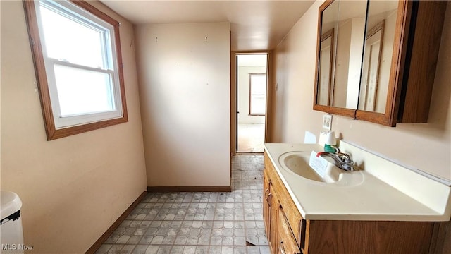 half bath featuring tile patterned floors, vanity, and baseboards