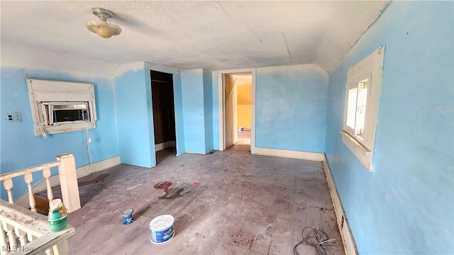 interior space featuring cooling unit, baseboards, and lofted ceiling