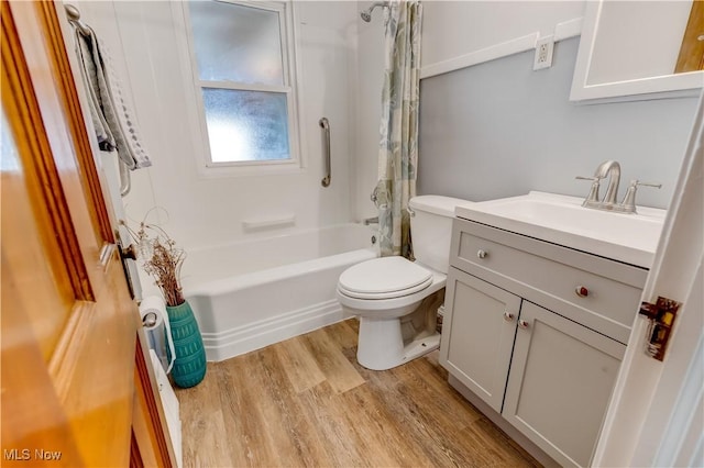 bathroom featuring shower / bath combo with shower curtain, toilet, wood finished floors, and vanity