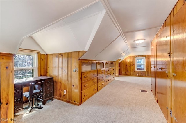 bonus room with visible vents, carpet floors, wooden walls, and lofted ceiling