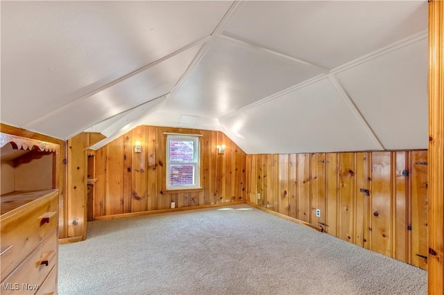 bonus room with lofted ceiling, wooden walls, and carpet floors