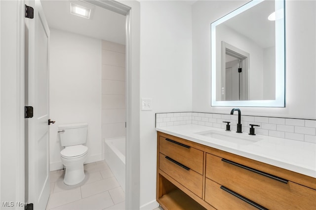 full bath featuring vanity, a tub to relax in, tile patterned floors, toilet, and tasteful backsplash